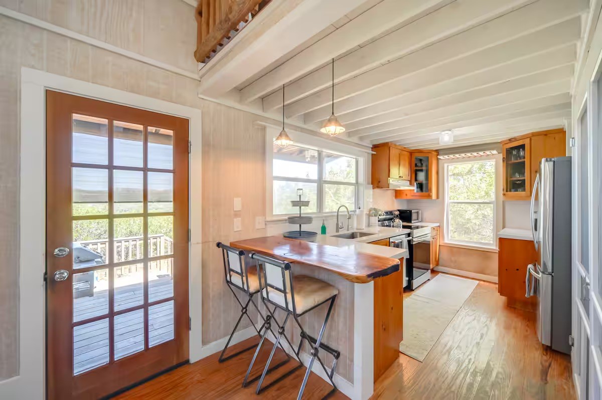17 September Ridge Johnson City, TX 78636 - Photo 10 of 40 Kitchen featuring stainless steel appliances, a peninsula, brown cabinetry, light wood-style floors, and a sink