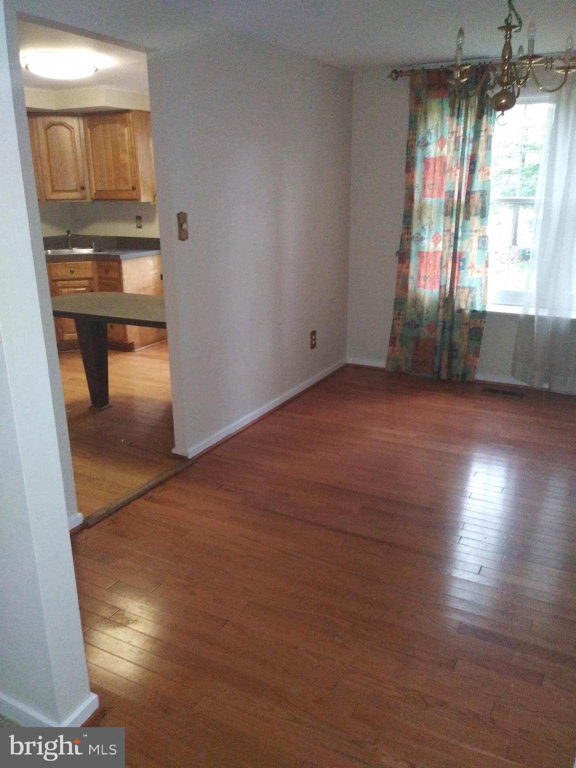 405 Trimble Road Joppa, MD 21085 - Photo 4 of 5 an empty room with wooden floor and windows
