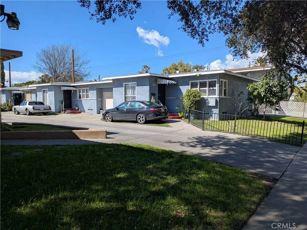 6809 Heliotrope Avenue Bell, CA 90201 - Photo 4 of 18 a front view of a house with a garden and trees