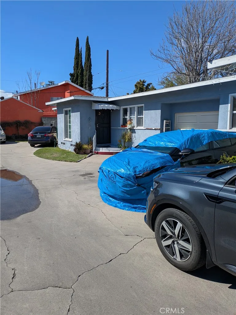6809 Heliotrope Avenue Bell, CA 90201 - Photo 9 of 18 a front view of a house with a garden and parking space
