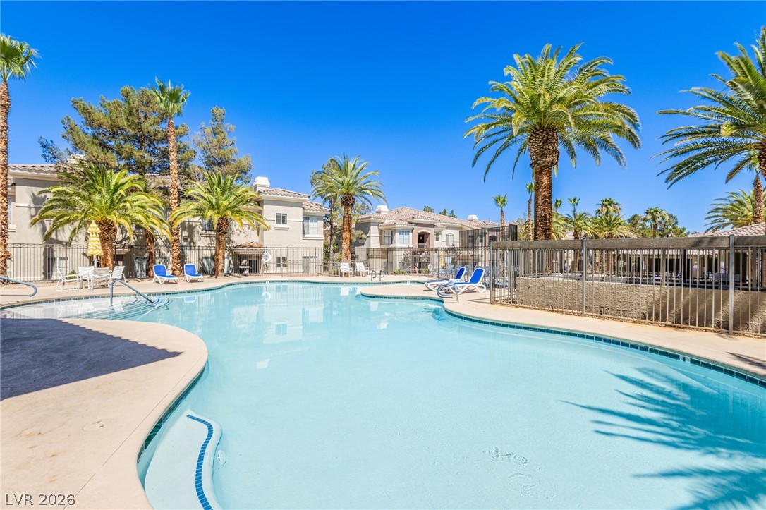 9050 West Warm Springs Road, Unit 1011 Las Vegas, NV 89148 - Photo 21 of 32 A tranquil oasis awaits with this community pool, lined with palm trees and sun loungers.