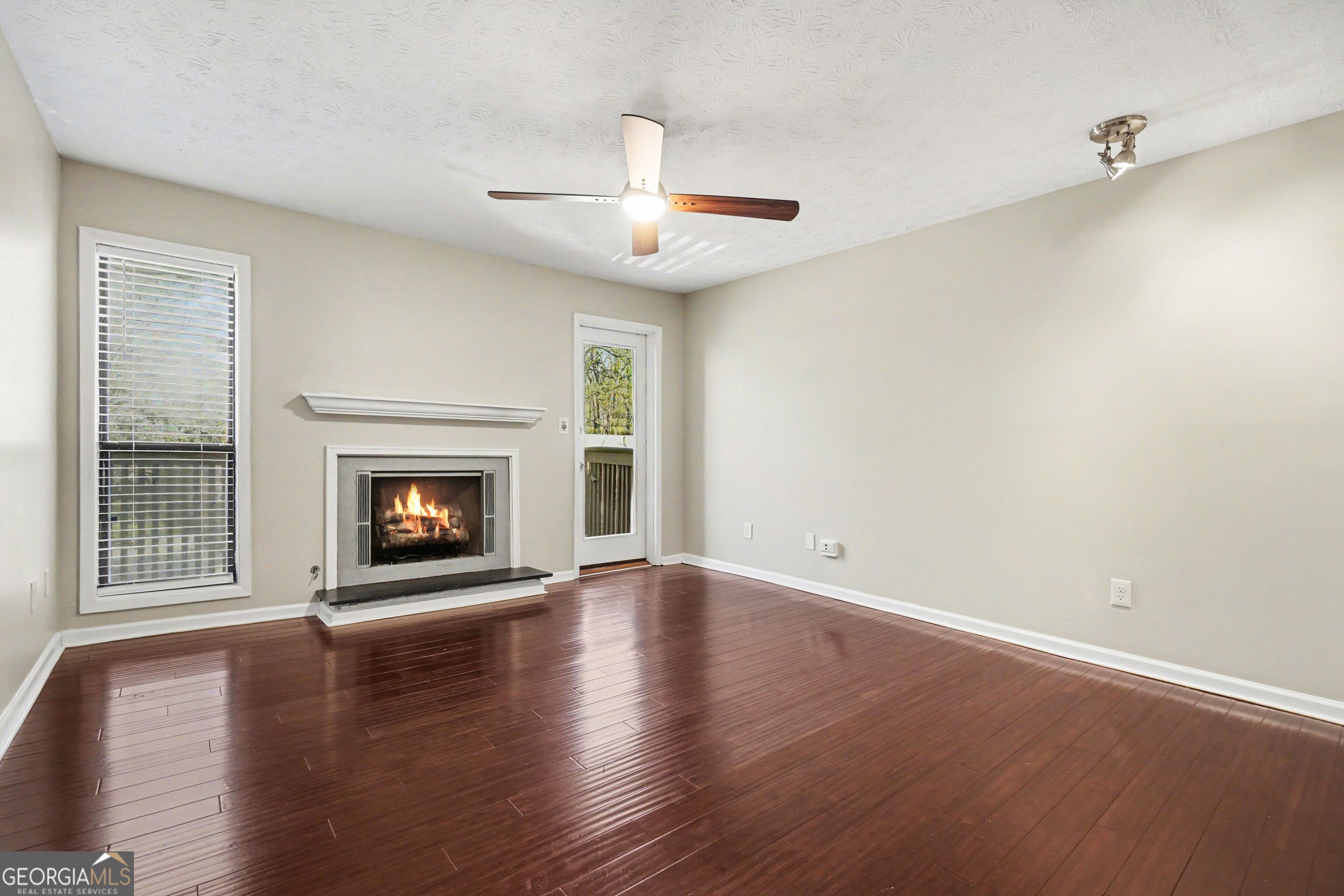 918 Dunbar Drive Atlanta, GA 30338 - Photo 3 of 16 an empty room with wooden floor fireplace and windows