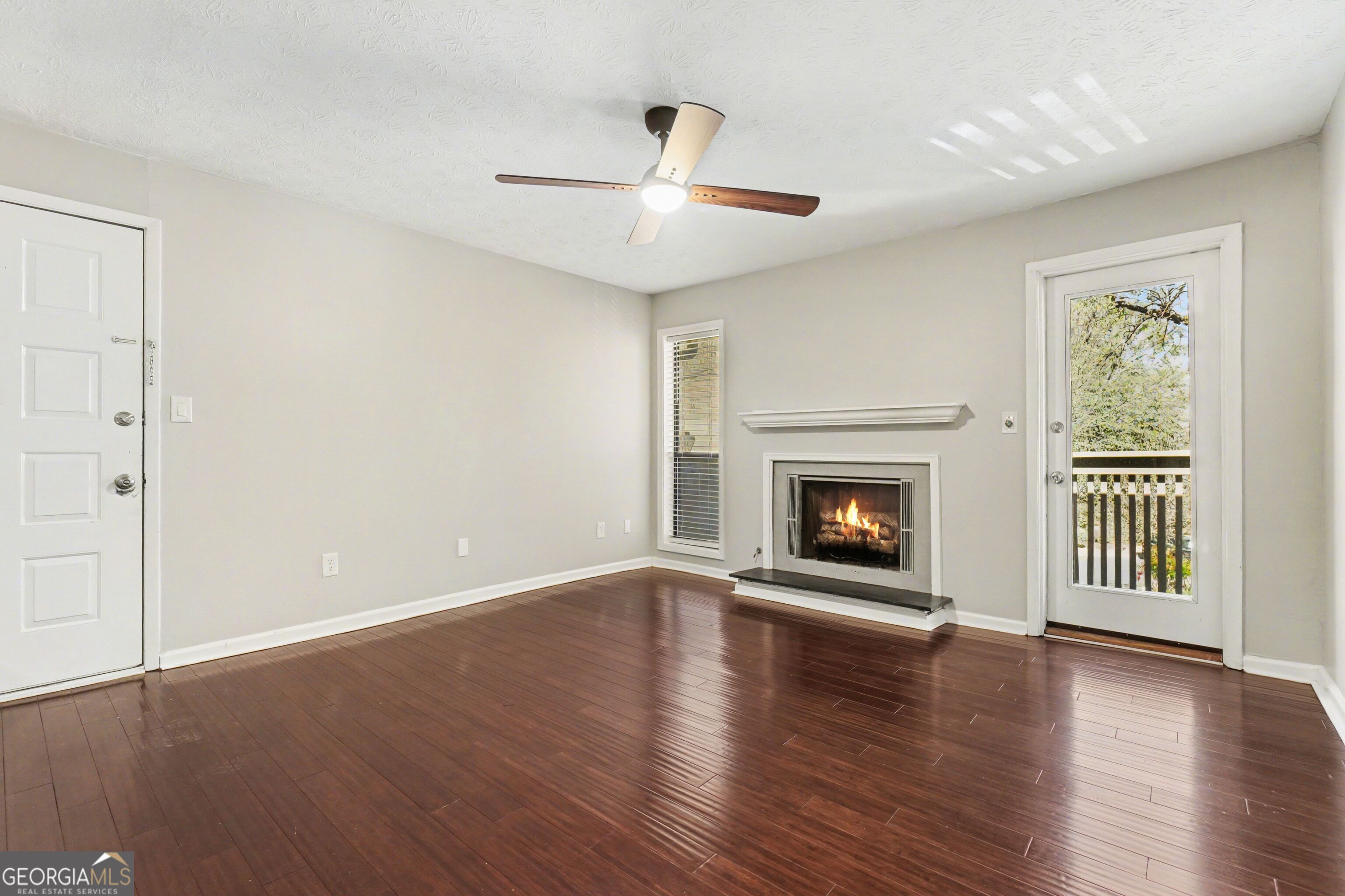 918 Dunbar Drive Atlanta, GA 30338 - Photo 4 of 16 an empty room with wooden floor fireplace and windows