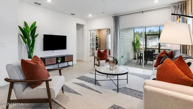 a bedroom with a bed lamp and a large window
