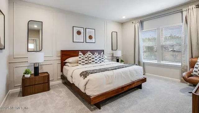 a bedroom with a bed mirror and a window