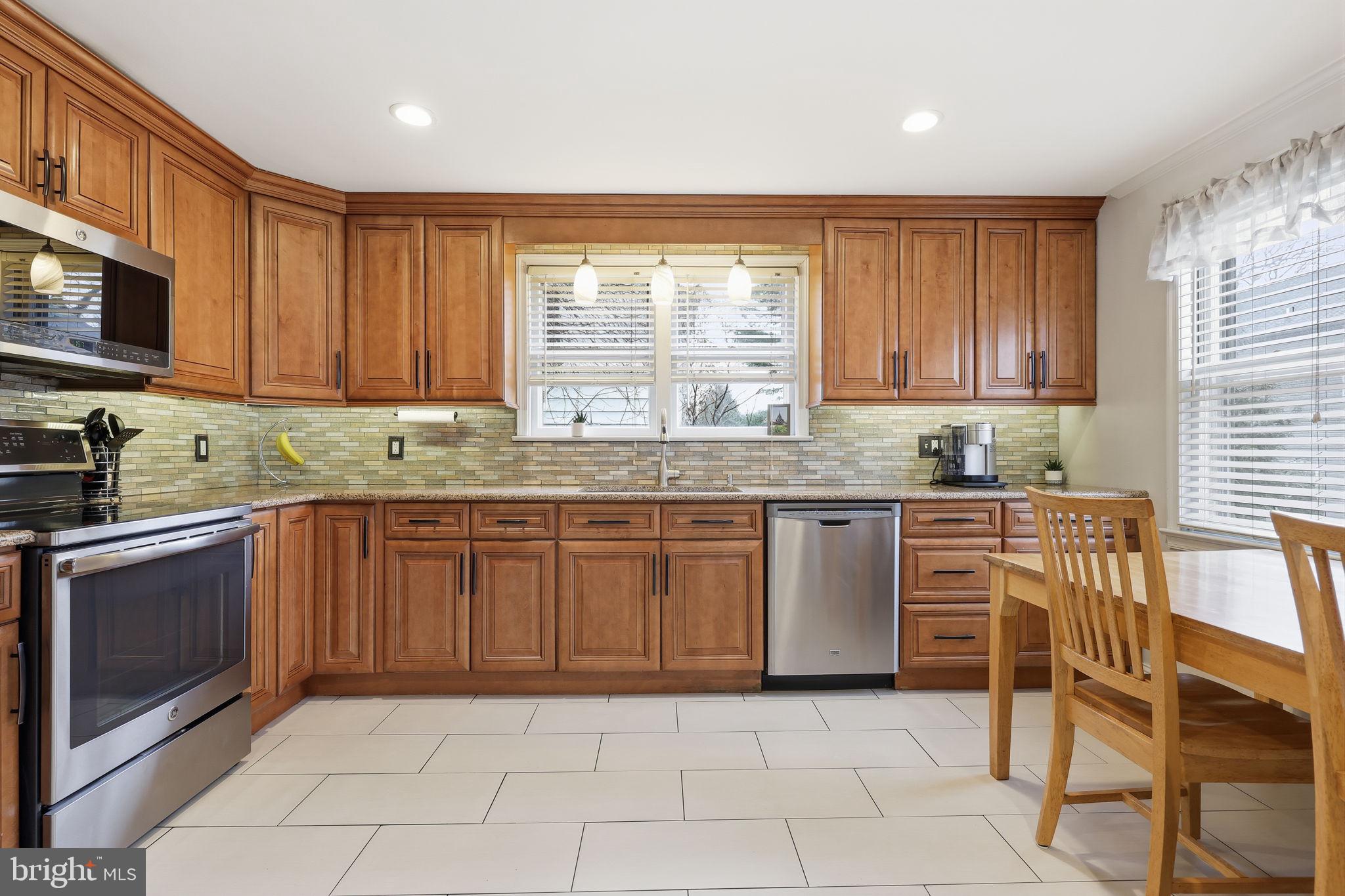 1607 Forrest Avenue Feasterville-Trevose, PA 19053 - Photo 11 of 48 a kitchen with stainless steel appliances granite countertop a stove a sink and a microwave