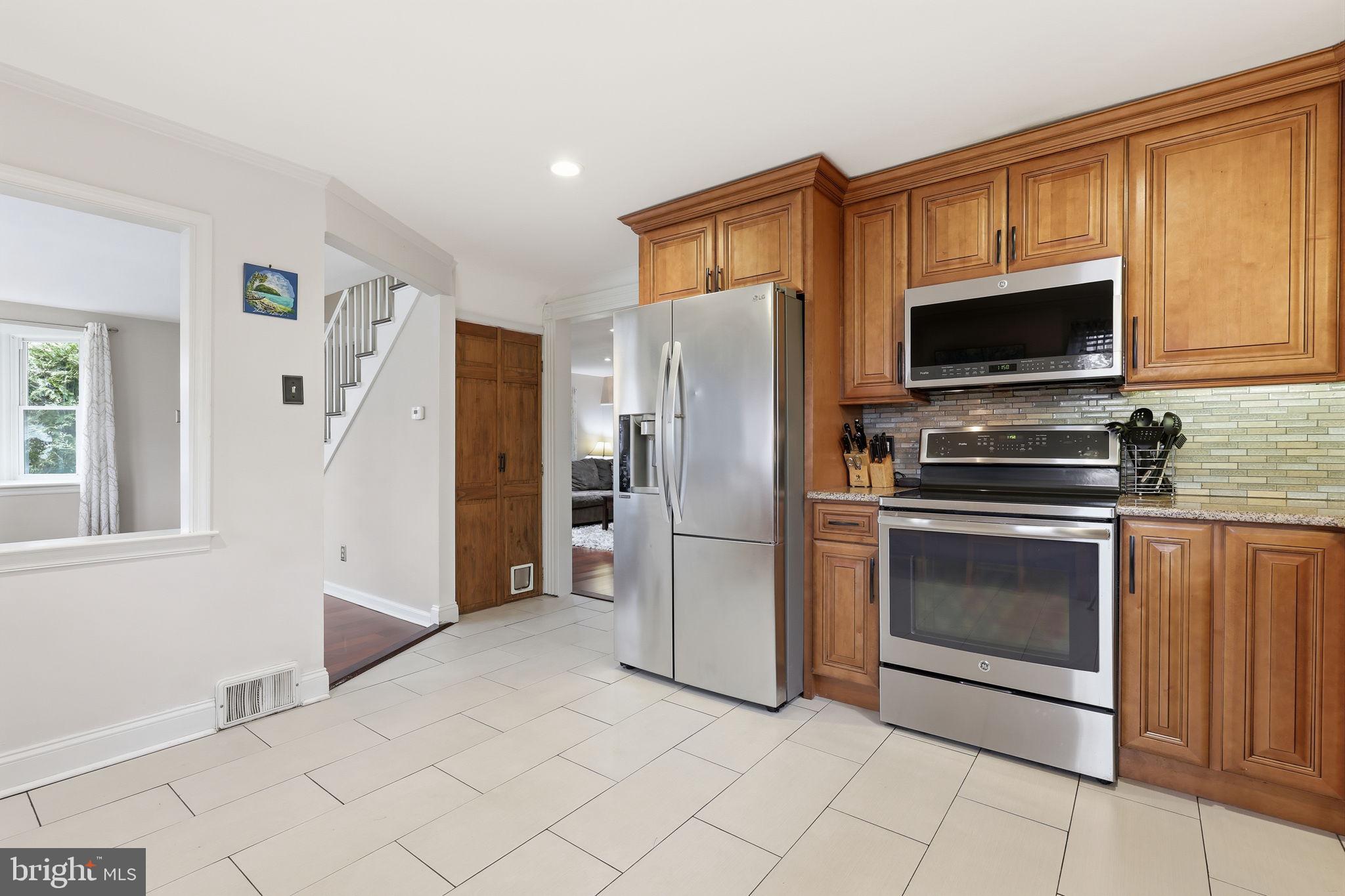 1607 Forrest Avenue Feasterville-Trevose, PA 19053 - Photo 14 of 48 a kitchen with granite countertop a refrigerator and a stove top oven