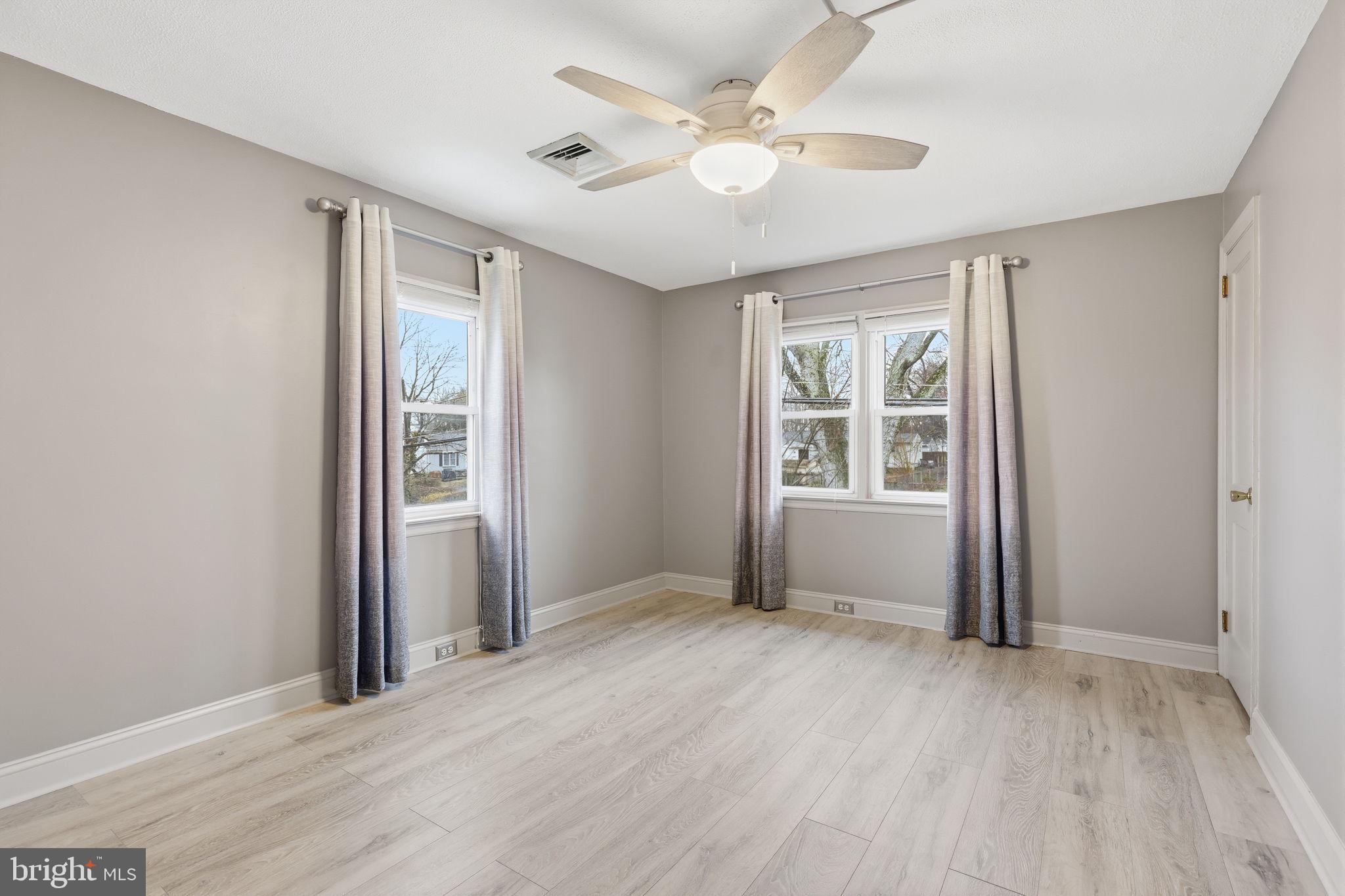 1607 Forrest Avenue Feasterville-Trevose, PA 19053 - Photo 24 of 48 an empty room with wooden floor ceiling fan and windows