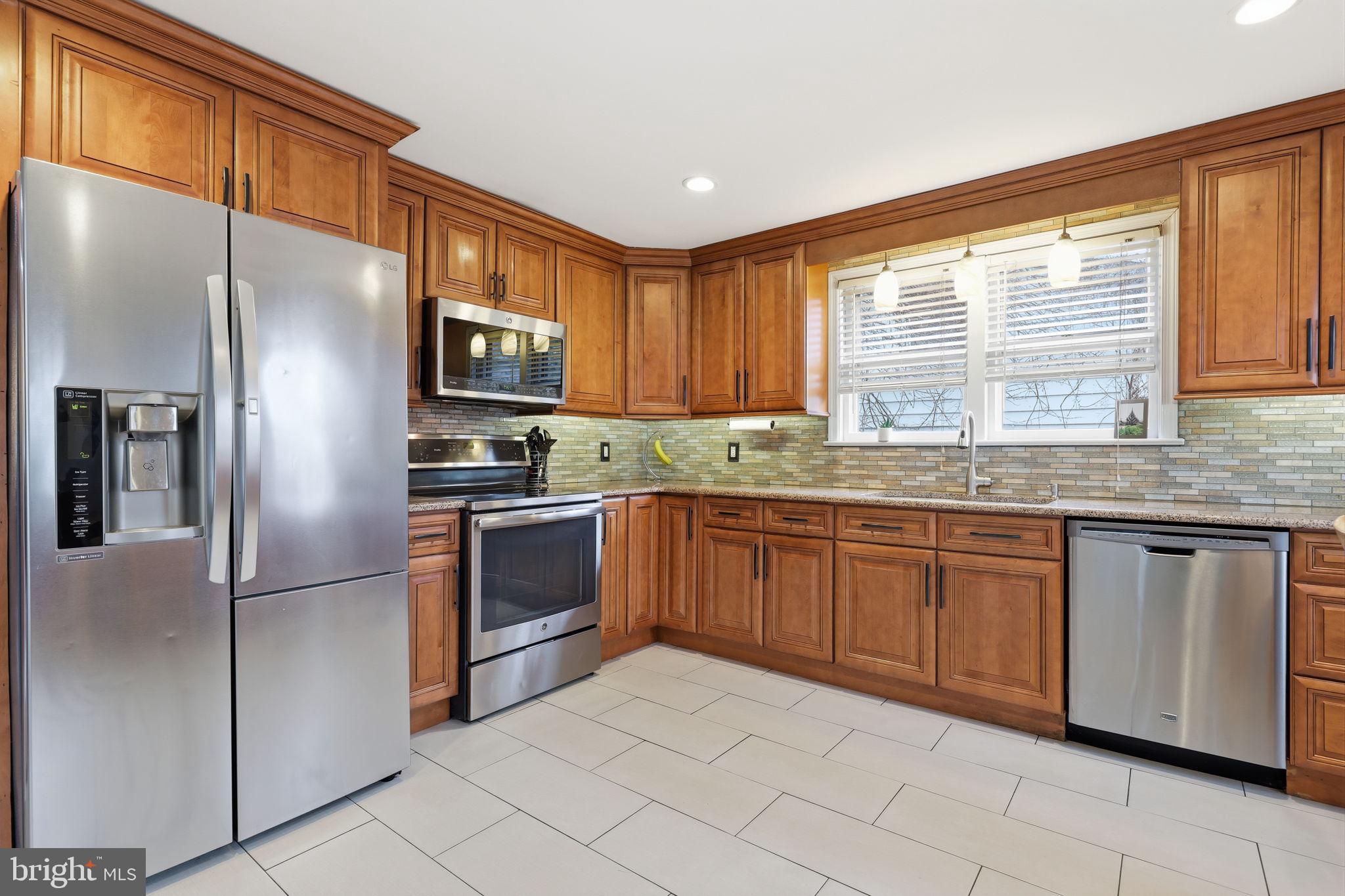 1607 Forrest Avenue Feasterville-Trevose, PA 19053 - Photo 10 of 48 a kitchen with granite countertop stainless steel appliances a refrigerator stove top oven and sink