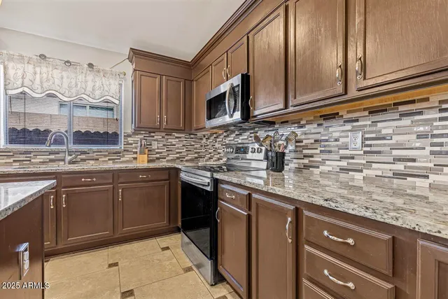 a kitchen with stainless steel appliances granite countertop a stove sink and cabinets