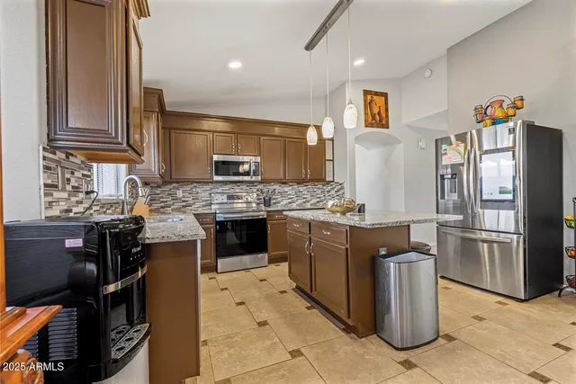 a kitchen with stainless steel appliances granite countertop a sink stove and microwave