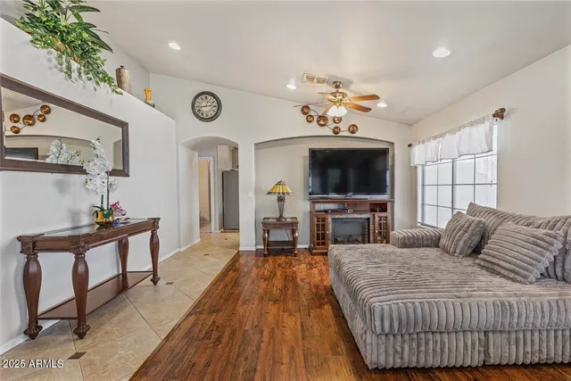 a living room with furniture a ceiling fan and a rug
