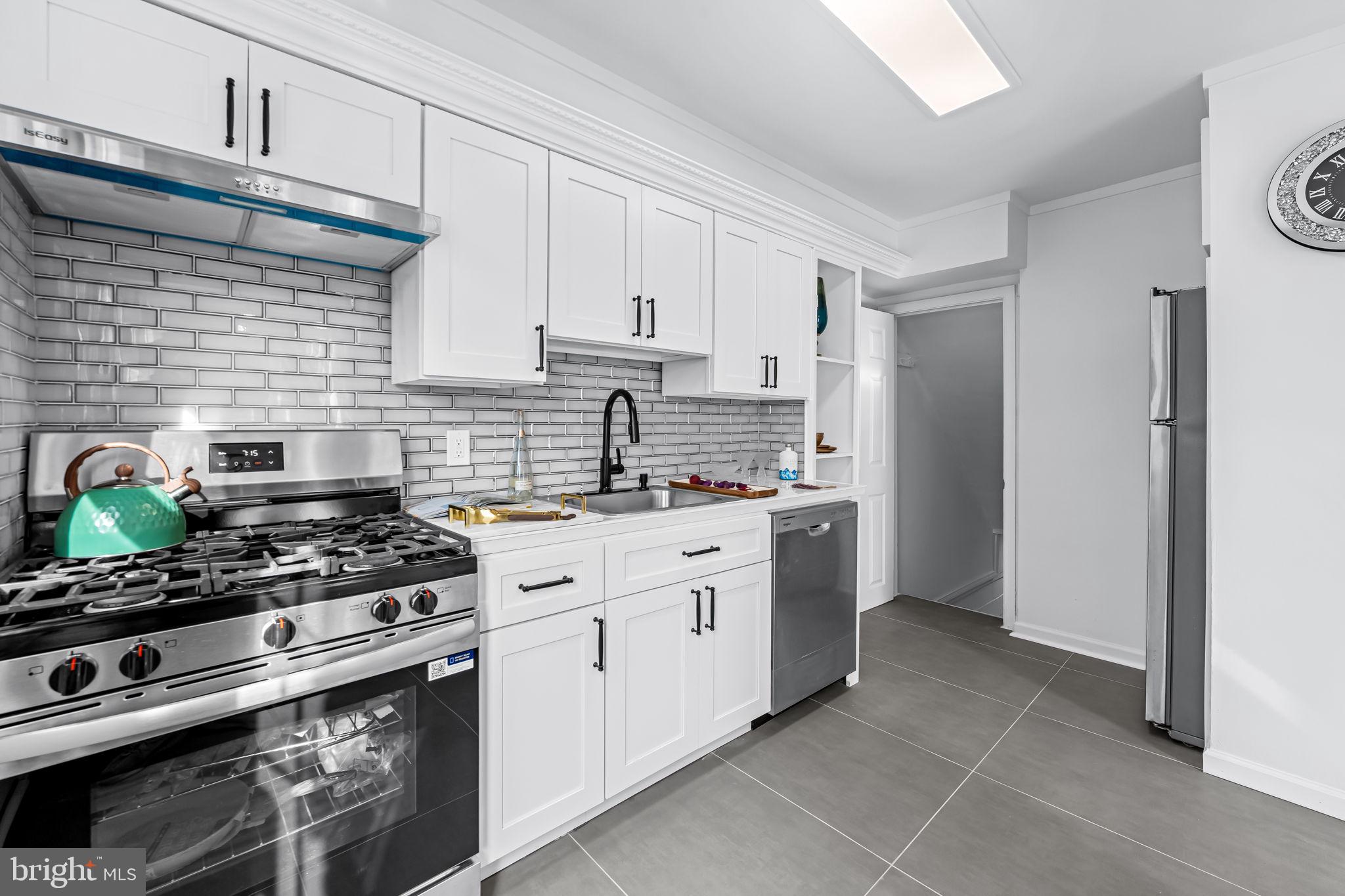 66 Stemmers Run Road Baltimore, MD 21221 - Photo 12 of 24 a kitchen with stainless steel appliances a stove a sink and a refrigerator