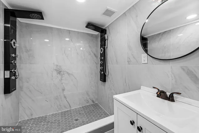 a bathroom with a sink a mirror and shower