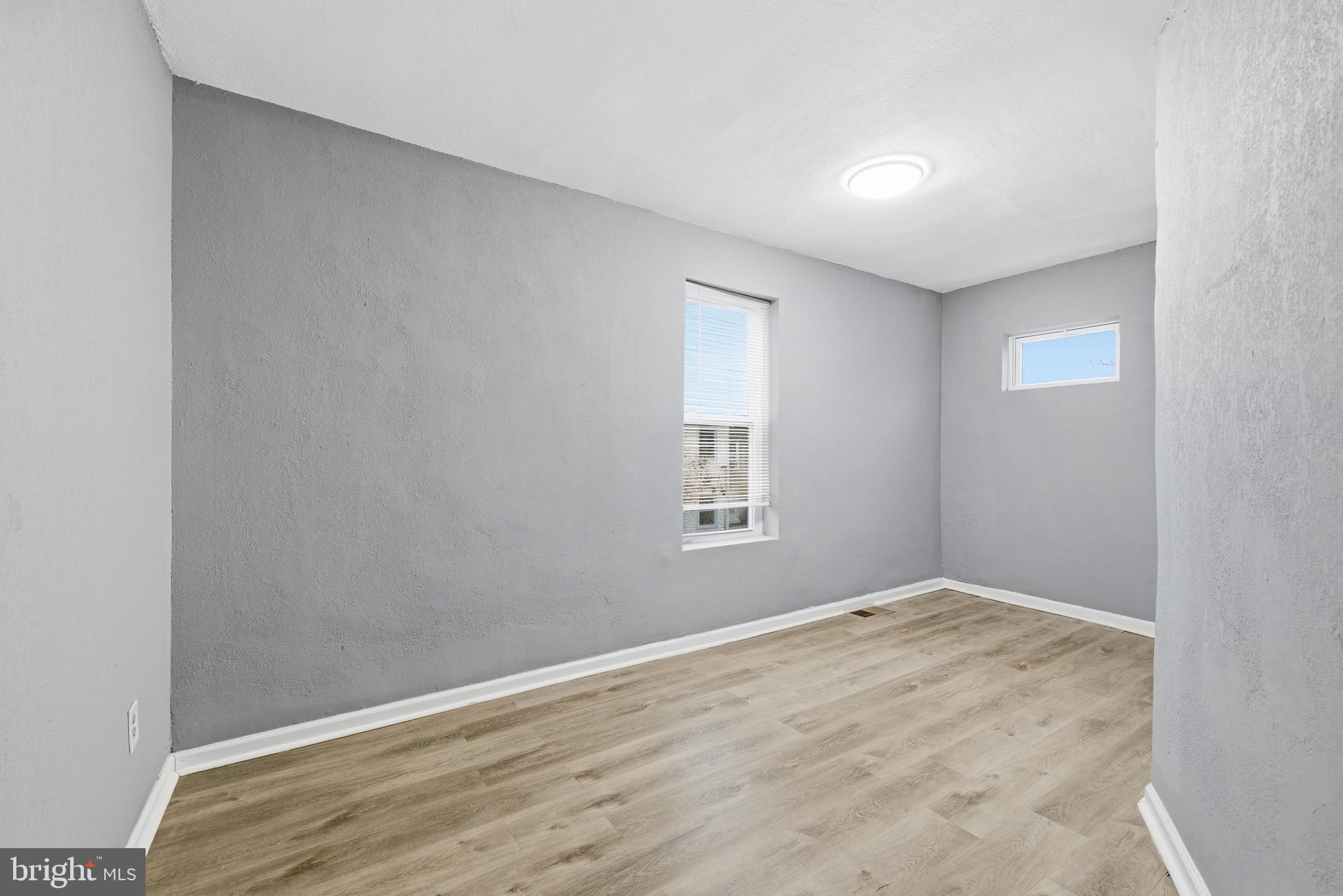 16 South Payson Street Baltimore, MD 21223 - Photo 13 of 16 an empty room with wooden floor and windows