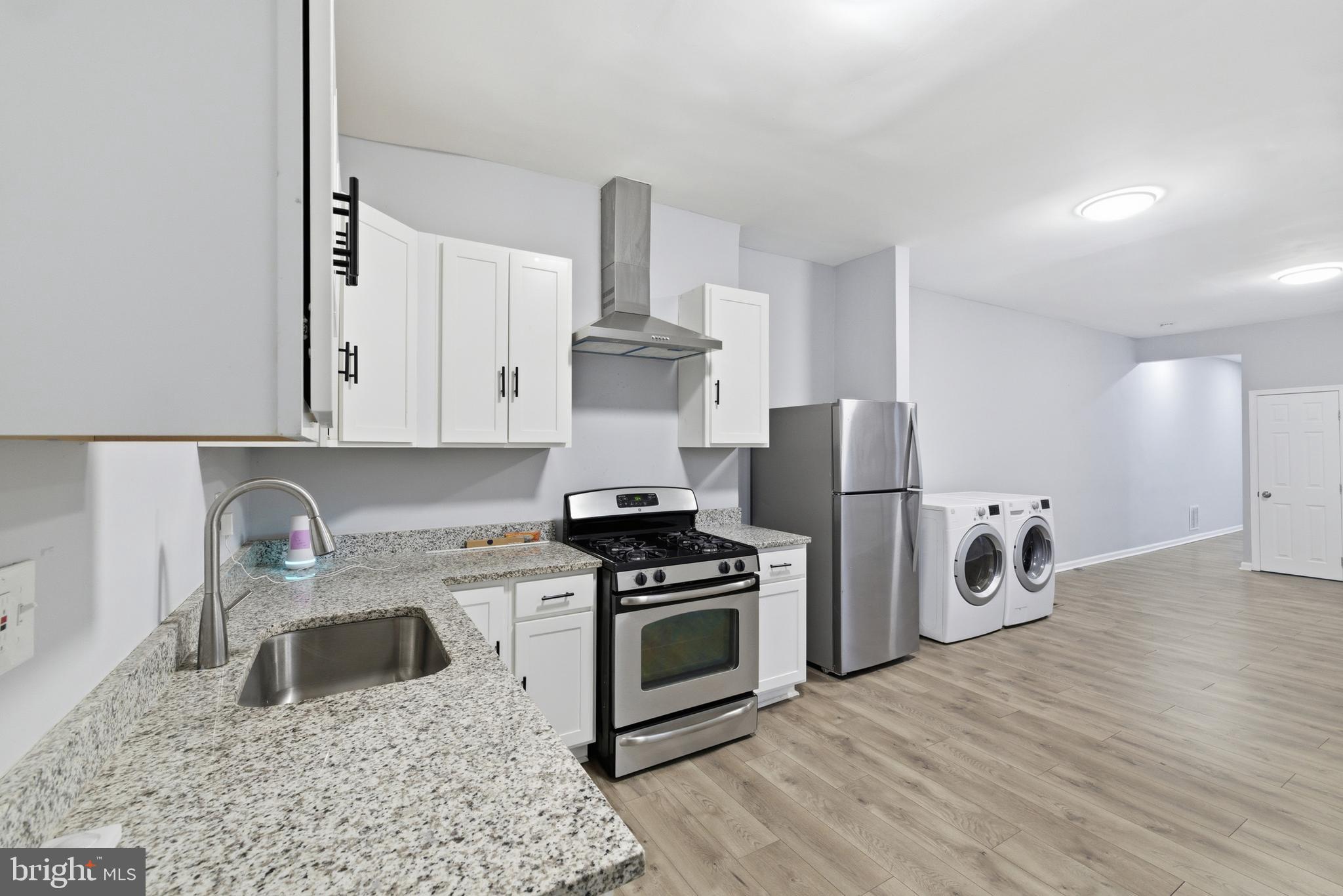 16 South Payson Street Baltimore, MD 21223 - Photo 7 of 16 a kitchen with granite countertop a stove and a refrigerator