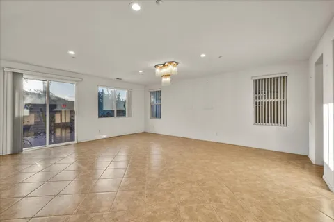 a view of an empty room and kitchen view