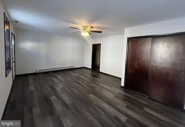 a view of a livingroom with wooden floor and a flat screen tv