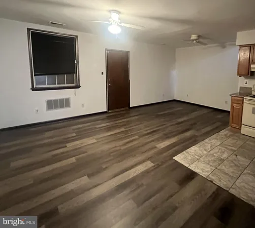 a view of a kitchen with wooden floor electronic appliances and stairs