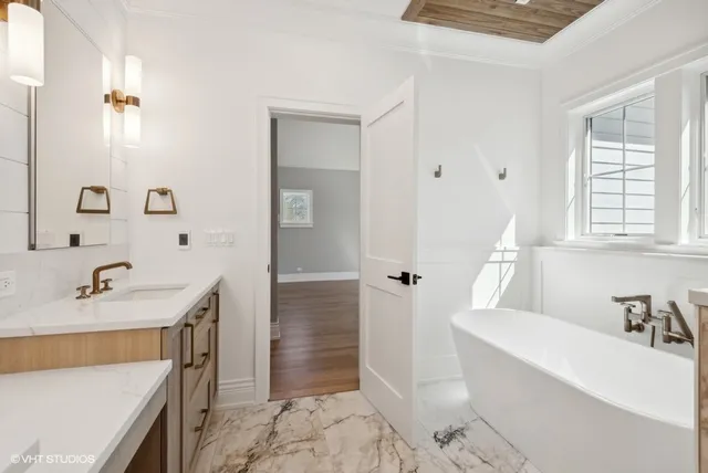 a bathroom with a tub sink and mirror