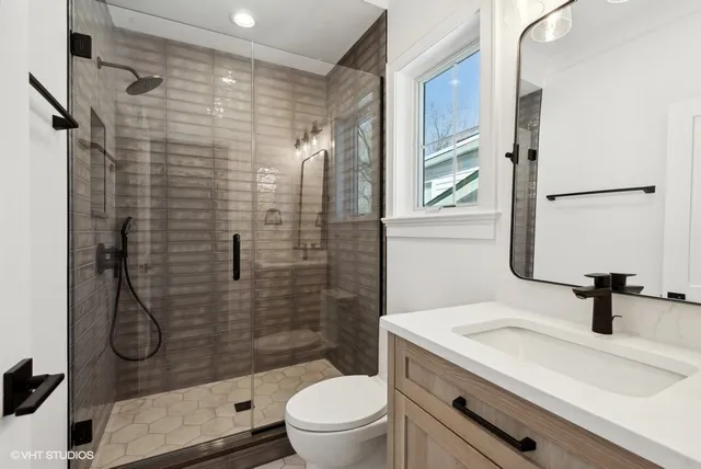 a bathroom with a sink a toilet and a shower