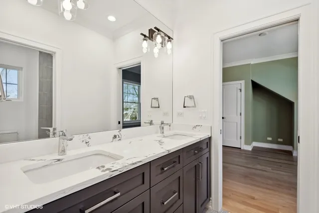 a bathroom with double vanity sinks and a mirror