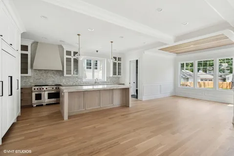 a large kitchen with stainless steel appliances granite countertop a stove and a large window