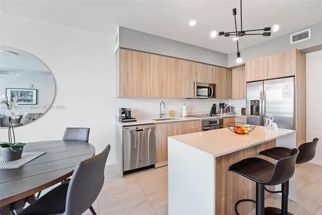 a kitchen with stainless steel appliances a sink a refrigerator and a stove