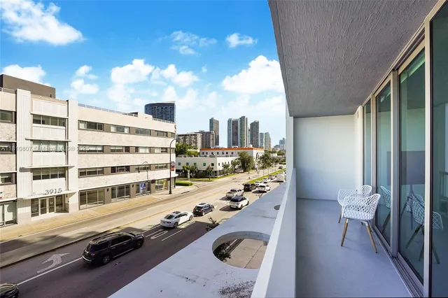 a view of a city from a balcony with furniture