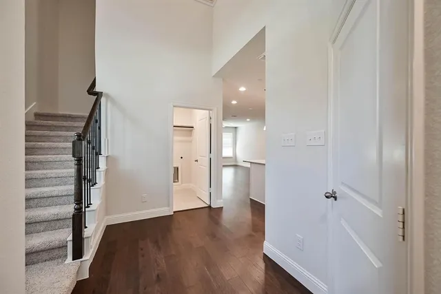 a view of a hallway with wooden floor and staircase