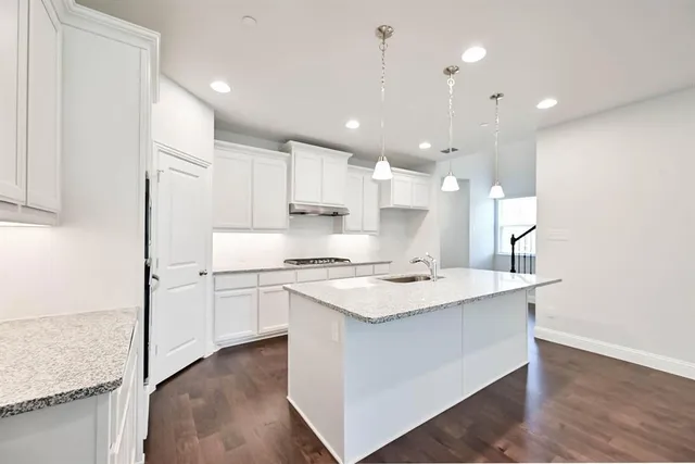 a kitchen with white cabinets and sink
