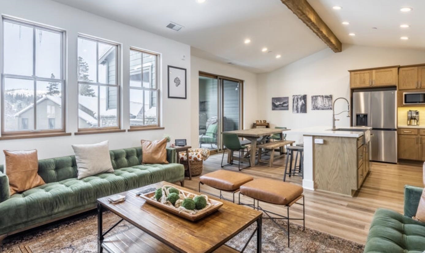 a living room with furniture kitchen view and a window