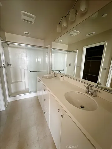 a bathroom with double vanity and a mirror