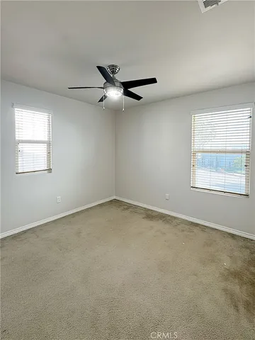 an empty room with a window and a fan