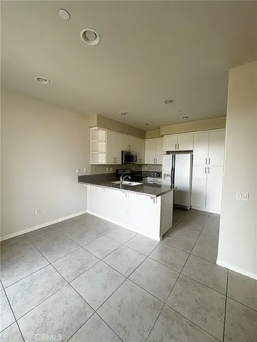 a kitchen with stainless steel appliances a sink a stove a refrigerator and cabinets