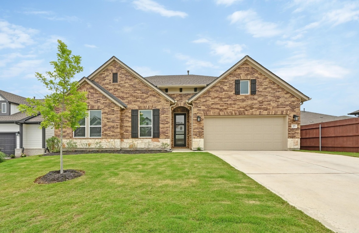 a front view of a house with a yard and garage
