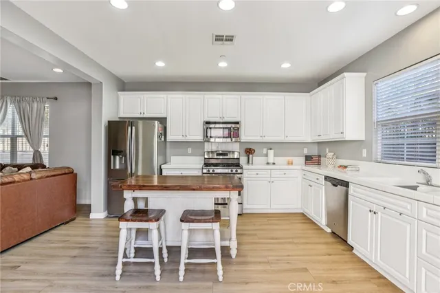 a kitchen with white cabinets and stainless steel appliances