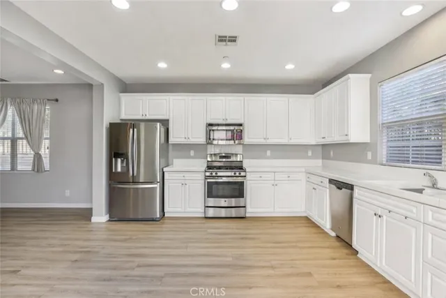 a kitchen with stainless steel appliances granite countertop a refrigerator and a stove top oven