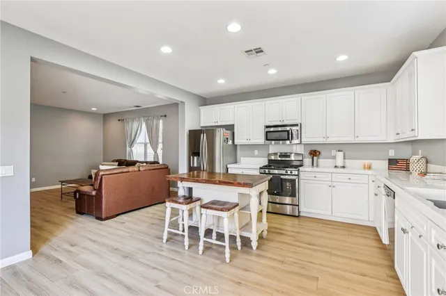 a kitchen with stainless steel appliances granite countertop wooden floors and cabinets