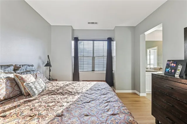 a bedroom with a bed and a mirror on dresser