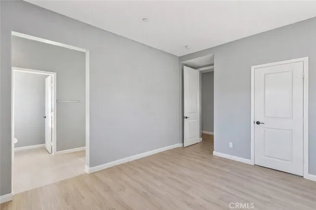 a bedroom with a bed and a wooden floor