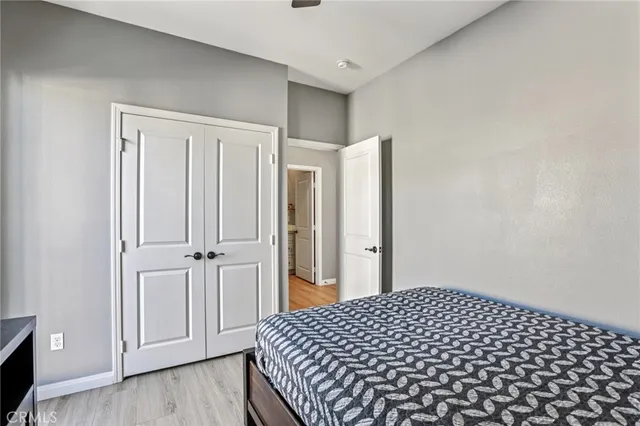 a view of a white house with potted plants and large tree
