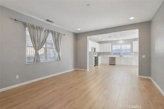 a view of a kitchen with wooden floor and a window
