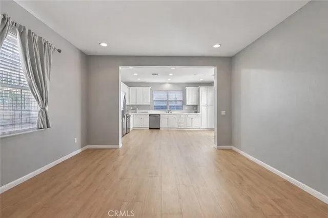 a view of a kitchen with wooden floor and a window