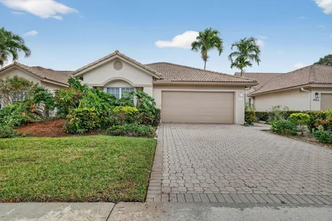 a view of a house with a yard and potted plants
