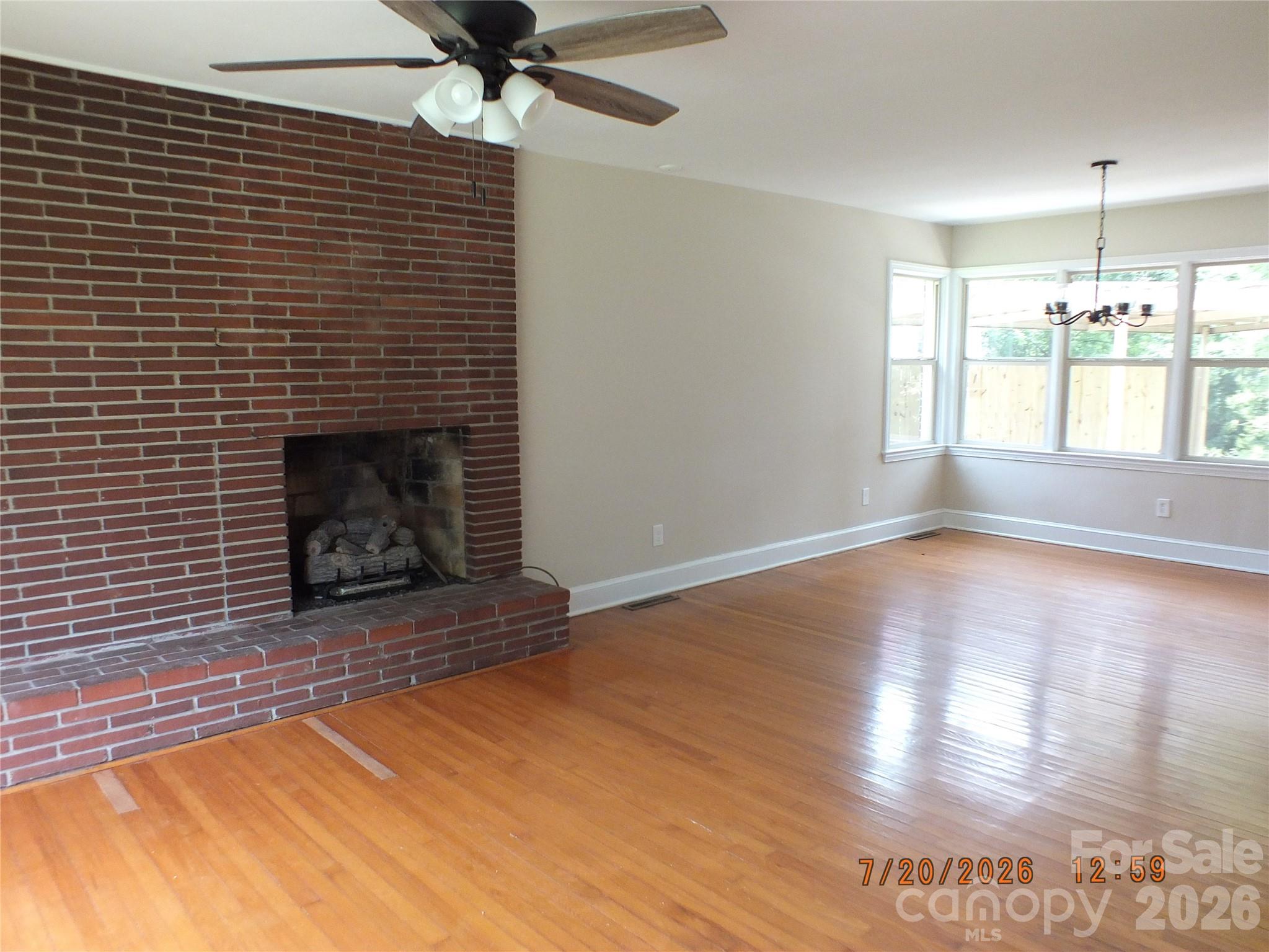 414 West Springs Street Lancaster, SC 29720 - Photo 3 of 22 a view of an empty room with wooden floor fireplace and a window