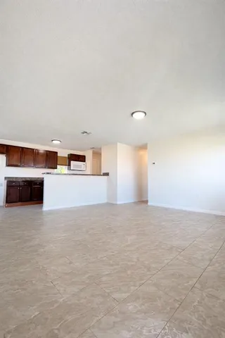 a view of empty room with kitchen