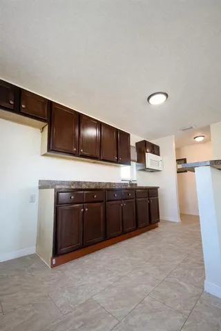 a large kitchen with stainless steel appliances granite countertop a stove a sink and a refrigerator