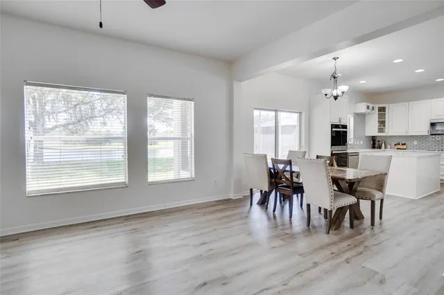 a view of dining room and livingroom with furniture wooden floor a rug a chandelier