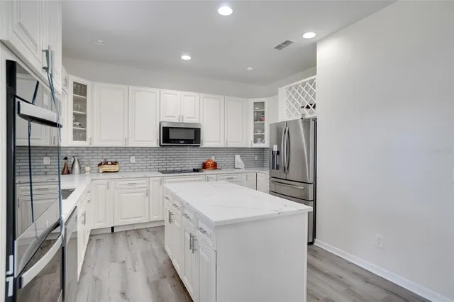 a kitchen with cabinets a refrigerator and a sink
